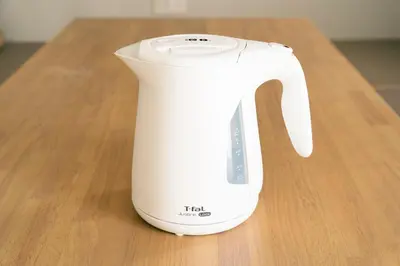 a white electric kettle sitting on a wooden table at Asakusa Sky Tokyo Condominium hotel in Tokyo