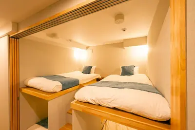 two beds in a small room with a mirror at Asakusa Sky Tokyo Condominium hotel in Tokyo