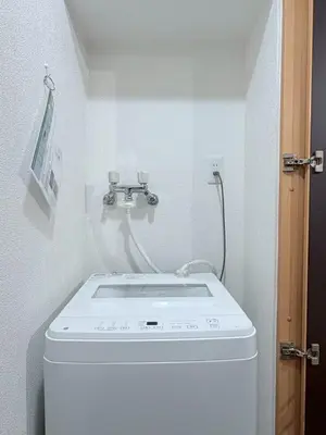a washer and dryer in a small bathroom at GARDEN HOUSE Shinjuku-Sanchome in Tokyo