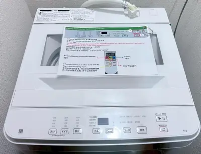 a washing machine with a paper on top of it at GARDEN HOUSE Shinjuku-Sanchome in Tokyo