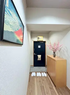 a waiting room with a locker and a tv on the wall at GARDEN HOUSE Shinjuku-Sanchome in Tokyo