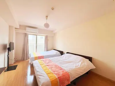 a bedroom with two beds and a window at \u30a2\u30eb\u30b9\u30db\u30fc\u30e0 \u6c60\u888b in Tokyo