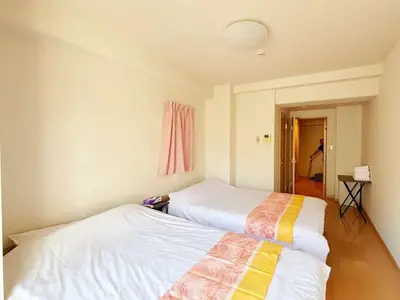two beds sitting next to each other in a room at \u30a2\u30eb\u30b9\u30db\u30fc\u30e0 \u6c60\u888b in Tokyo