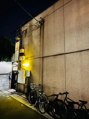 two bikes parked next to a building at night at Tokyo Shinjuku East Goose Goose House in Tokyo