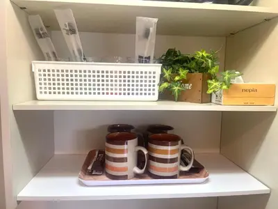 a cupboard with two coffee mugs on a shelf at Tokyo Shinjuku East Goose Goose House in Tokyo