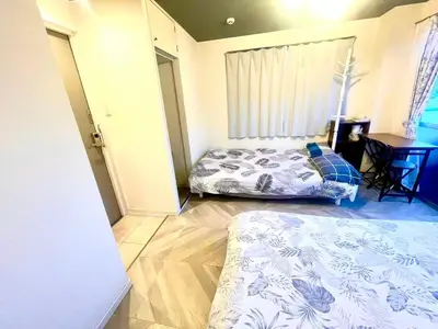 a bedroom with two beds and a table in it at Tokyo Shinjuku East Goose Goose House in Tokyo