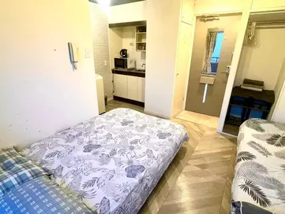 a small room with a bed and a kitchen at Tokyo Shinjuku East Goose Goose House in Tokyo