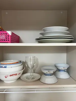 a shelf with plates and bowls and a wine glass at \u6771\u65b0\u5bbf\u30a8\u30ea\u30a277 in Tokyo