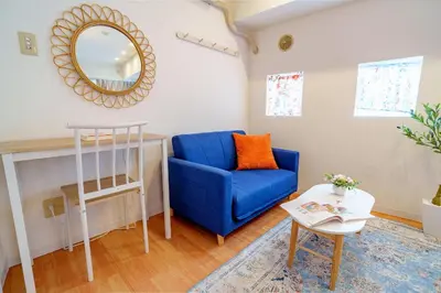 a living room with a blue chair and a mirror at -Higashi-shinjuku 9F- Entire floor rental in Tokyo
