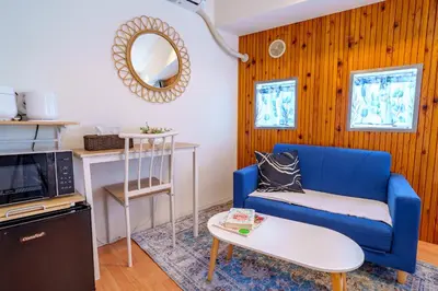 a living room with a blue couch and a mirror at -Higashi-shinjuku 9F- Entire floor rental in Tokyo