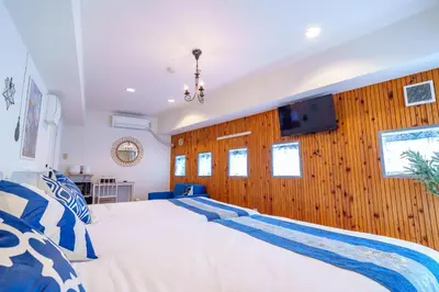 a bedroom with a large bed and wooden walls at -Higashi-shinjuku 9F- Entire floor rental in Tokyo
