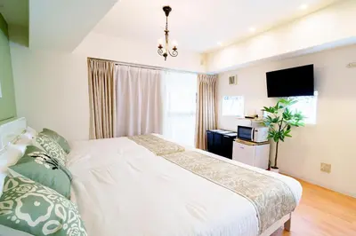 a bedroom with a white bed and a television at -Higashi-shinjuku 9F- Entire floor rental in Tokyo