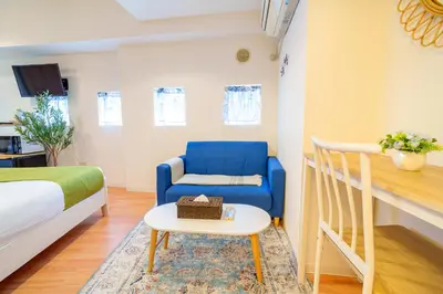 a room with a bed and a blue chair and a table at -Higashi-shinjuku 9F- Entire floor rental in Tokyo