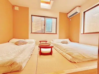 a room with two beds and a table in it at Ueno&Asakusa Stay Whole House for 11, Great Access in Tokyo