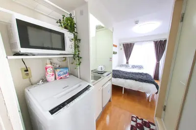 a small kitchen with a washer and dryer in a tiny house at \u30cf\u30a4\u30af\u30ec\u30b9\u30c8\u4e2d\u91ce103 in Tokyo