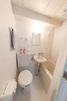 a white bathroom with a toilet and a sink at \u30cf\u30a4\u30af\u30ec\u30b9\u30c8\u4e2d\u91ce103 in Tokyo