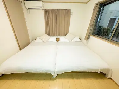 a bed in a small room with a window at Shinjuku Cozy Loft, 2BR, 3DoubleBeds&Living in Tokyo