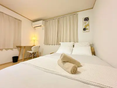 a bedroom with a white bed and a desk at Shinjuku Cozy Loft, 2BR, 3DoubleBeds&Living in Tokyo