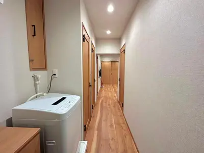 a hallway with a washing machine in a room at A\u65b0\u5bbf\u6700\u4e2d\u5fc3 \u6b4c\u821e\u4f0e\u753a 3bedrooms 2bathrooms 2toiltes\u6b65\u884c\u5230\u4e1c\u65b0\u5bbf4\u5206\u949f \u6b65\u884c\u5230\u65b0\u5bbf9\u5206\u949f Max8 in Tokyo