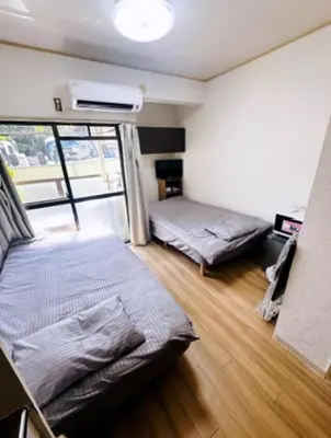 a bedroom with two beds and a window at Tokyo Shinjuku Goose Goose Apart in Tokyo