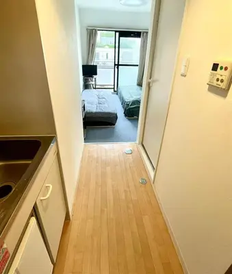 a hallway with a door to a room with a bed at Tokyo Shinjuku Goose Goose Apart in Tokyo