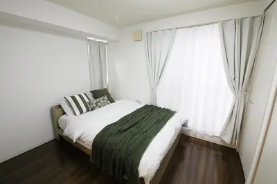 a bedroom with a bed and a large window at Guest House KAMEARI 203 in Tokyo