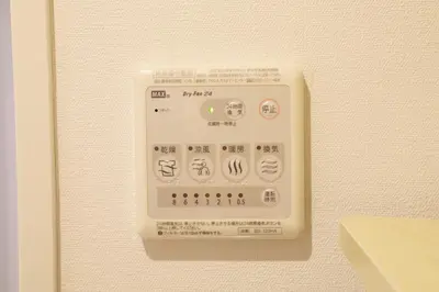 a white electrical outlet on a wall with writing on it at Guest House KAMEARI 203 in Tokyo