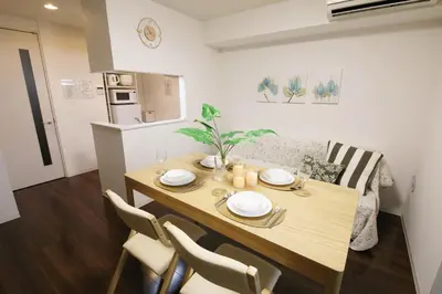 a dining table and chairs in a living room at Guest House KAMEARI 203 in Tokyo