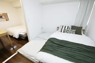 a bedroom with a bed and a mirror at Guest House KAMEARI 203 in Tokyo