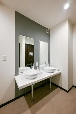 a bathroom with two sinks and two mirrors at Seed INN Iori-\u5eb5- in Tokyo