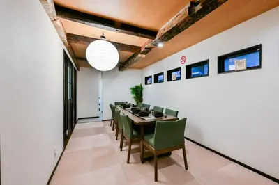 a dining room with a table and green chairs at Seed INN Iori-\u5eb5- in Tokyo