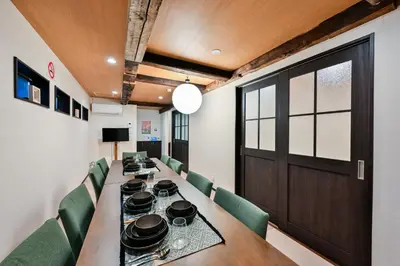 a dining room with a long table and green chairs at Seed INN Iori-\u5eb5- in Tokyo