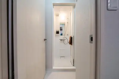 a bathroom with a shower and a white door at Lucky you! SHIBUYA in Tokyo