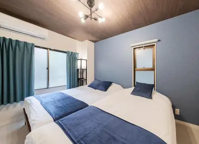 two beds in a bedroom with blue and white at Lucky you! SHIBUYA in Tokyo