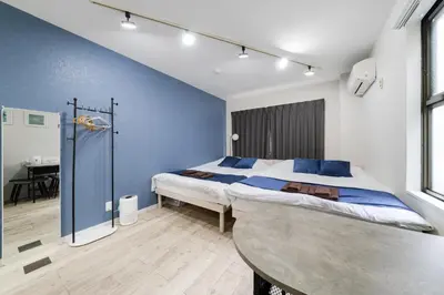 a bedroom with a bed and a table in it at Lucky you! SHIBUYA in Tokyo