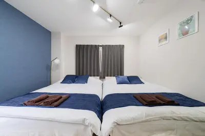 two beds in a bedroom with blue and white at Lucky you! SHIBUYA in Tokyo