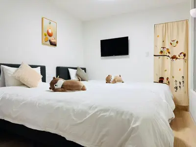 two stuffed animals are laying on a white bed at Shinagawa City \u834f\u539f101-SN0479 in Tokyo
