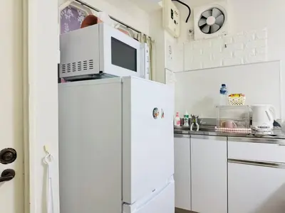 a kitchen with a microwave on top of a refrigerator at Shinagawa City \u834f\u539f101-SN0479 in Tokyo