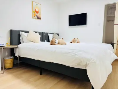 two teddy bears are sitting on a large bed at Shinagawa City \u834f\u539f101-SN0479 in Tokyo