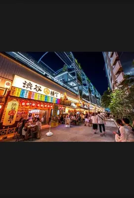 a group of people walking in front of a building at \u6a31\u82b1\u5bbf\u6d89\u8c37\u7ad9\u5f92\u6b654\u5206\u949f in Tokyo