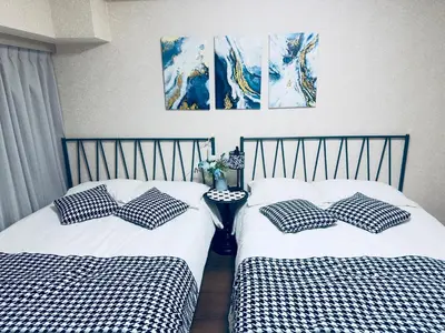 two beds with black and white pillows in a room at \u6a31\u82b1\u5bbf\u6d89\u8c37\u7ad9\u5f92\u6b654\u5206\u949f in Tokyo
