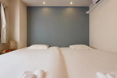 two beds in a room with white sheets at Silvership Hotel 201 in Tokyo