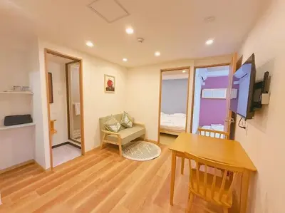a living room with a desk and a table and a room at Silvership Hotel 301 in Tokyo