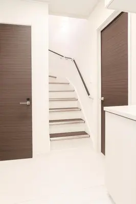a staircase in a house with white walls and wooden doors at Retreat BABA in Tokyo