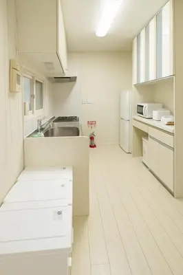 a white kitchen with a sink and a refrigerator at Retreat BABA in Tokyo