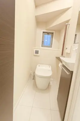 a white bathroom with a toilet and a window at Retreat BABA in Tokyo