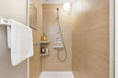 a bathroom with a shower with a glass door at Silvership Hotel 502 in Tokyo
