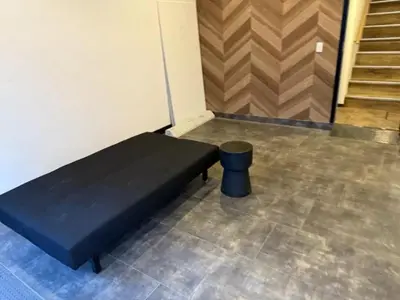 a black bed in a room with a stool at Silvership Hotel 502 in Tokyo