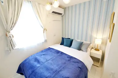 a bedroom with a blue and white bed with a window at \u30aa\u30fc\u30d6\u30ea\u30aa\u30f3\u6075\u6bd4\u5bff201 in Tokyo