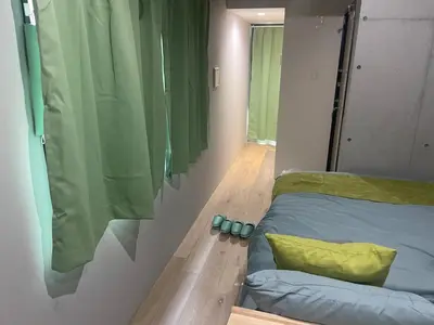 a bedroom with a bed with a yellow pillow at Green Apple Otsuka 201 in JR Otsuka station in Tokyo